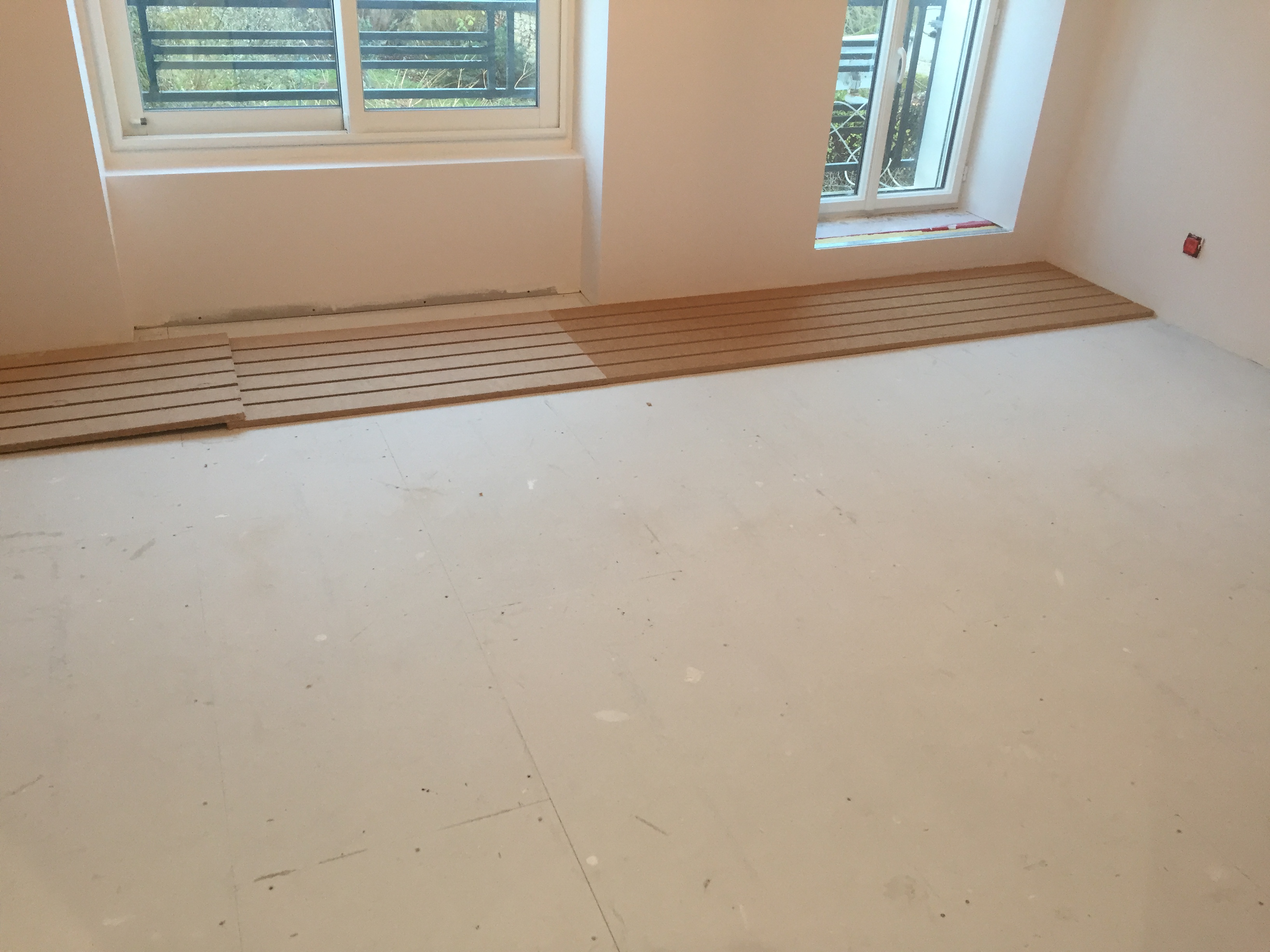 Plancher chauffant ECO+ en cours de pose en face de la cloison sans raillage