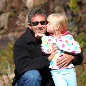 Joe Caron holding daughter in portrait