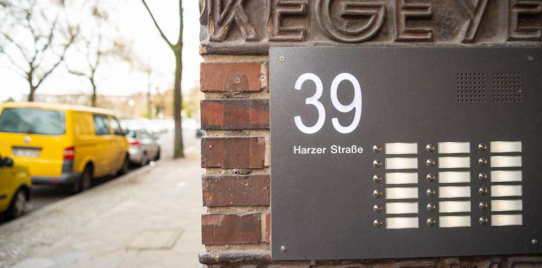 Two entrepeneurs sit by a green door of betahaus coworking space in Moritzplatz at an event