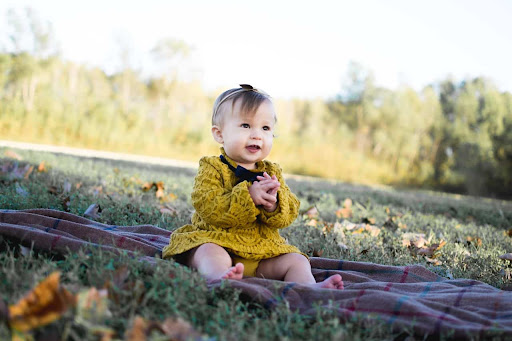 baby girl sitting outside laughing