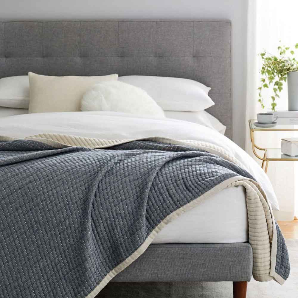 West Elm blanket draped across the end of a bed