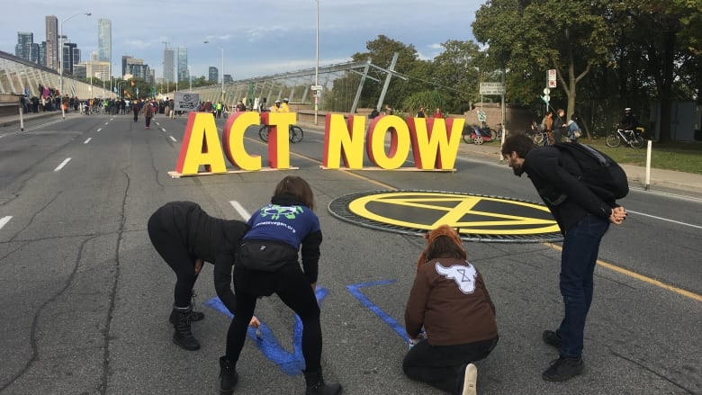Demonstrators painted the roadway on the Bloor Viaduct during the shutdown Monday. (Mark Bochsler/CBC)