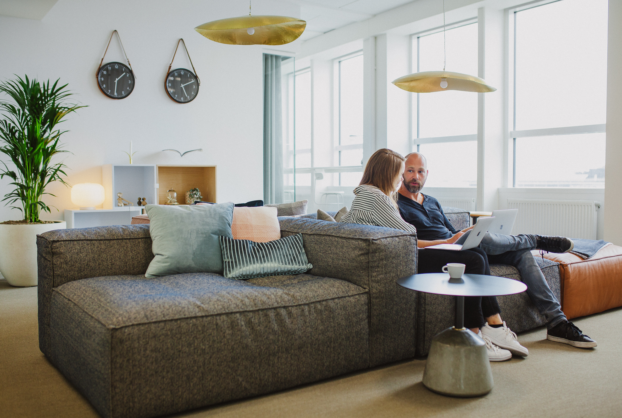 Content Managers talking while sitting in a comfortable couch.
