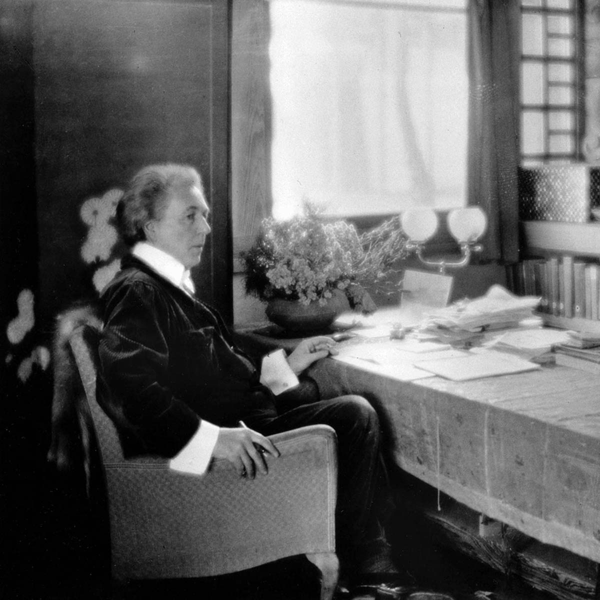Frank Lloyd Wright Sits at a Table