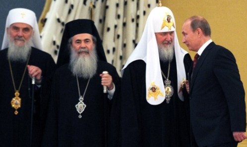 Russian President Vladimir Putin (R) talks with Russia's Patriarch Kiril (2nd R) during a family photo following the meeting with Orthodox leaders at the Kremlin in Moscow on July 25, 2013. AFP PHOTO / POOL / ALEXANDER NEMENOV