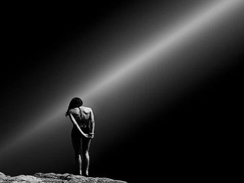 mujer de espaldas con rayo de luz