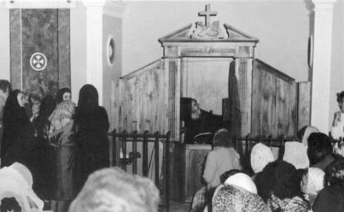 Padre Pio confesando y multitud esperando