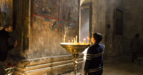 prendiendo velas frente a una pintura