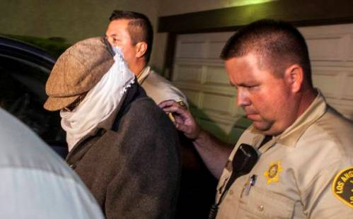 REFILE - UPDATING CAPTION WITH IDENTITY OF PERSON BEING ESCORTED Nakoula Basseley Nakoula (L) is escorted out of his home by Los Angeles County Sheriff's officers in Cerritos, California September 15, 2012. Nakoula, a California man convicted of bank fraud has been escorted to an interview with federal officers probing possible probation violations stemming from the making of an anti-Islam video that has triggered violent protests in the Muslim world, police said on Saturday. A Los Angeles County Sheriff's spokesman said Nakoula voluntarily left his home, accompanied by sheriff's deputies, to meet with the officers in the Cerritos Sheriff's Station. The obscure 13-minute English-language video, which was filmed in California and circulated on the Internet under several titles including "Innocence of Muslims," portrays Prophet Mohammad engaged in crude and offensive behavior. REUTERS/Bret Hartman (UNITED STATES - Tags: RELIGION CRIME LAW POLITICS)