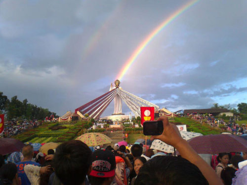 Estatua de Jesus de la Misericordia con arco iris arriba
