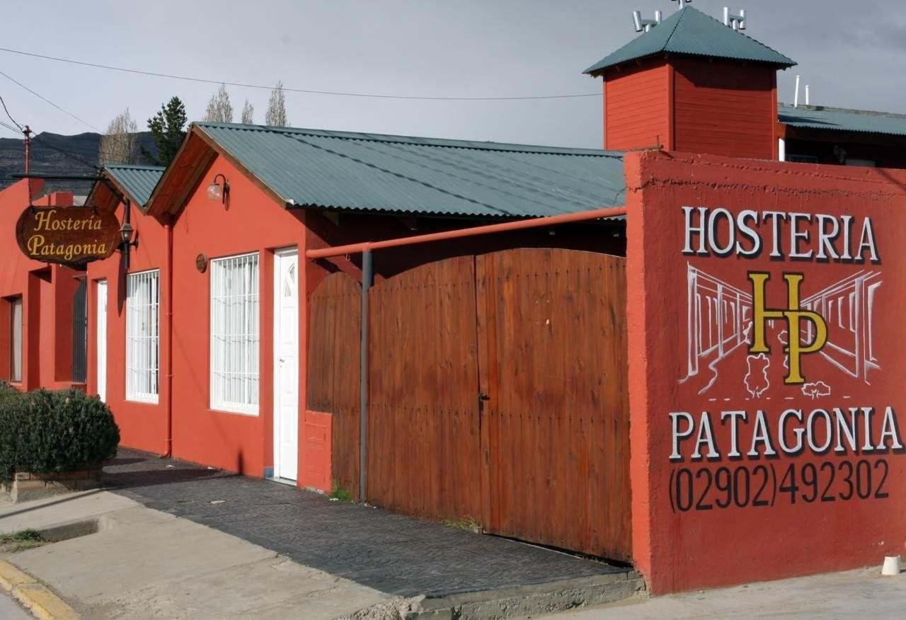 A red painted building that has a painted sign reading 'Hosteria Patagonia'