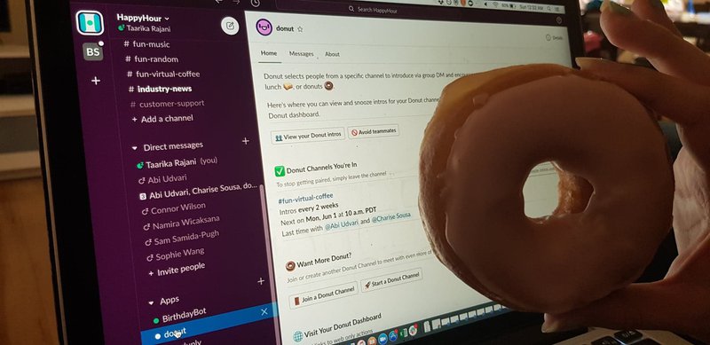 A real donut held in front of Donut, the slack app