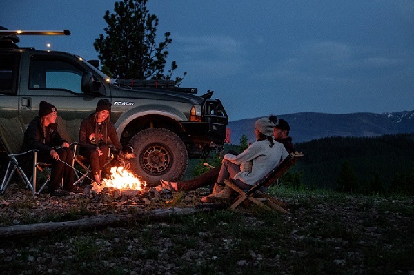Campers by campsite enjoying campfire using iOverlander.