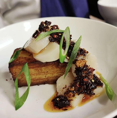 Scallops plated with sauce and delicious sides