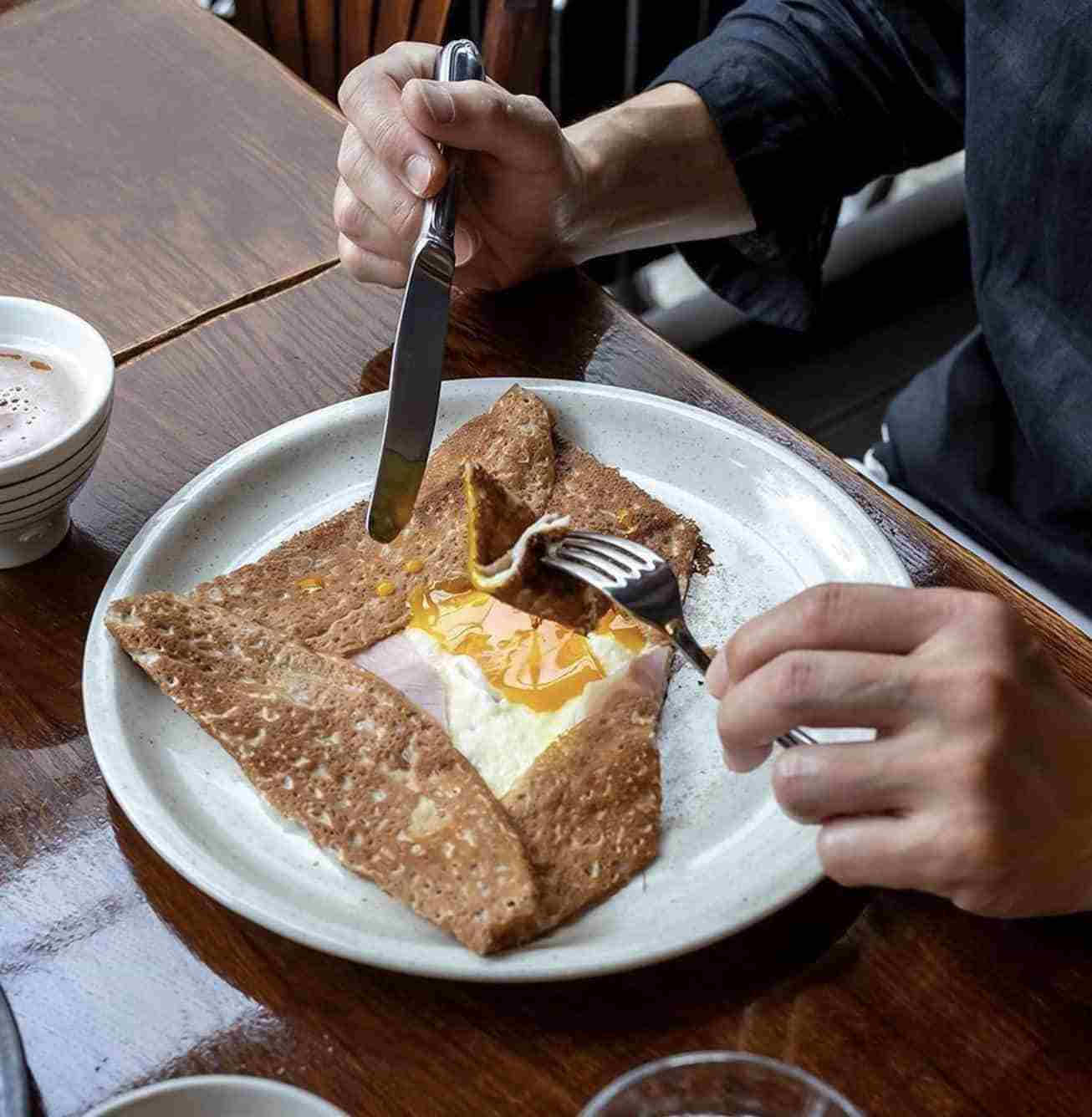 person cutting into french dish
