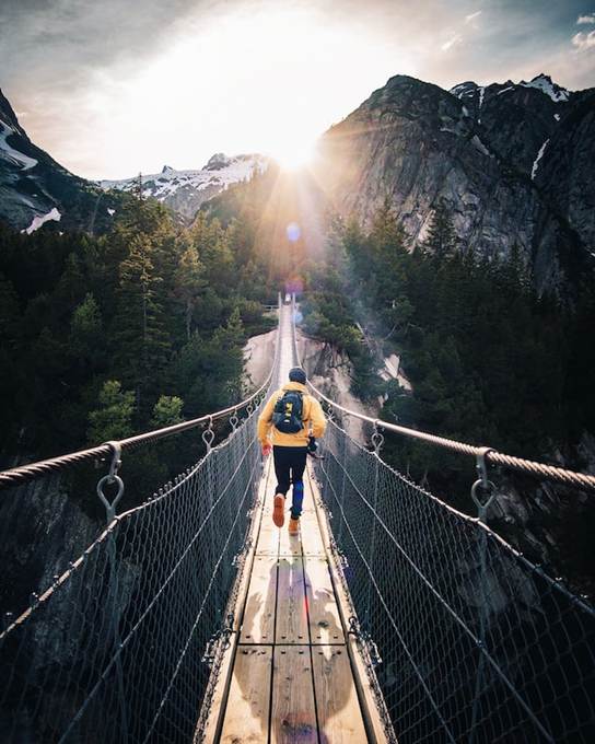 adventurer crossing a wooden bridge