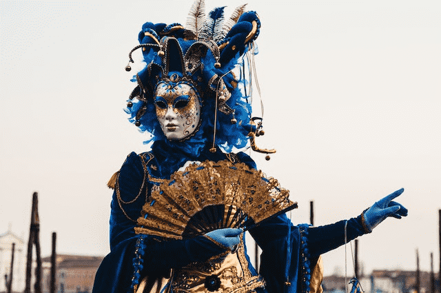Person in blue venetian costume during festival in Venice