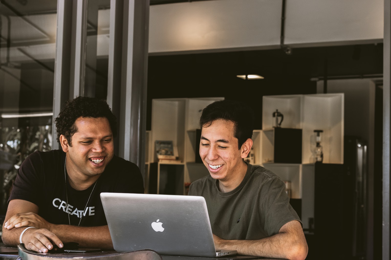 An office manager smiling as an employee happily shows his skills on a computer