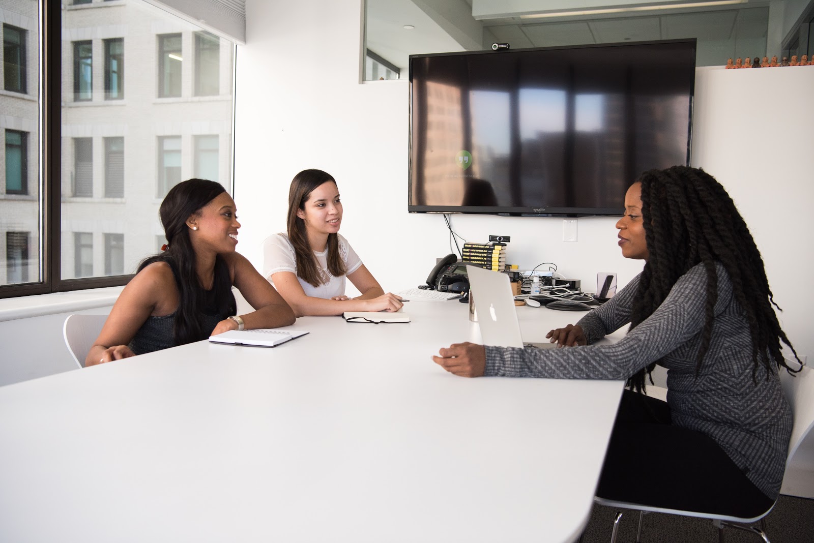 A hiring manager sitting at a table with two prospective internal hires