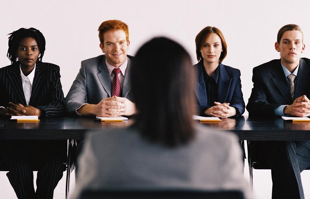 A candidate sitting before an interview panel
