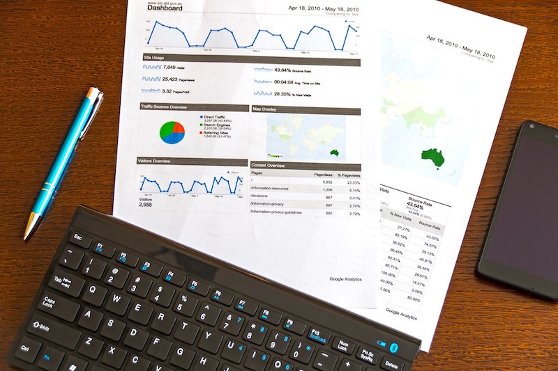 A sales chart laying on a desk next to a keyboard