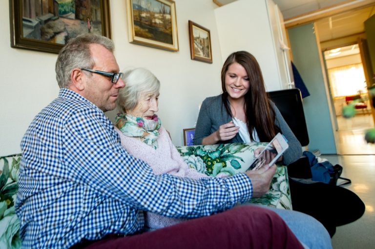 mann, eldra dame og yngre kvinne bruker MinMemoria sammen
