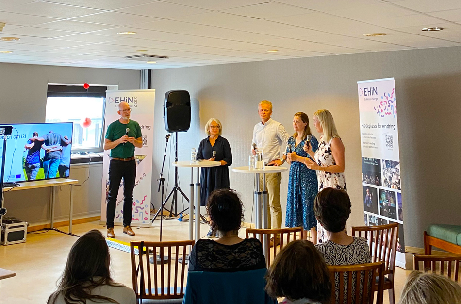 arrangement med fem stående personer som snakker