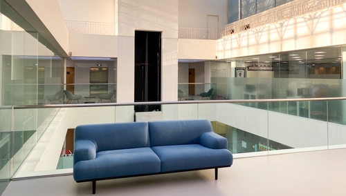 Photograph of inside a bright white office with a blue couch.