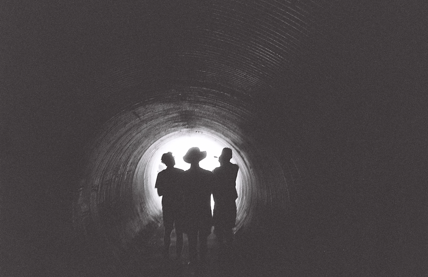 sillouette of 3 boys in a tunnel