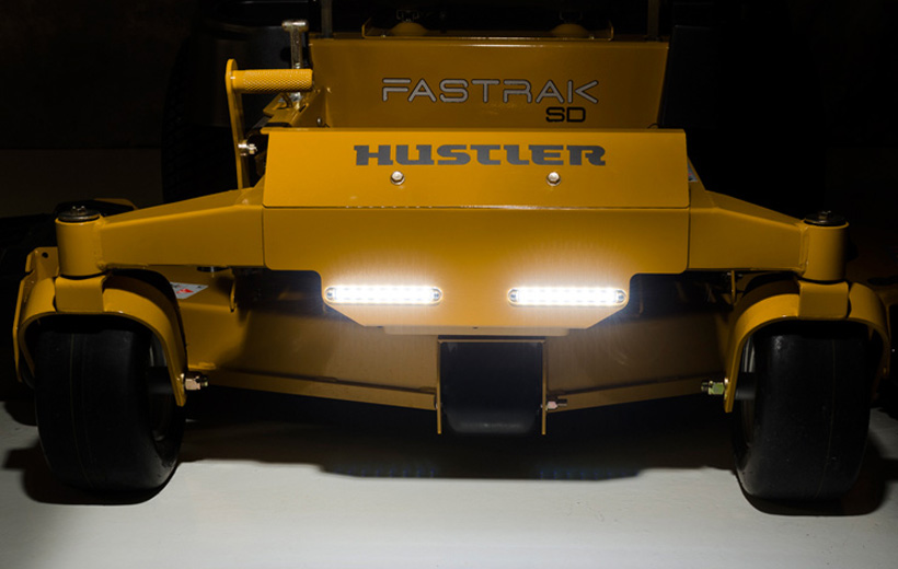 Image of the front of a yellow mower with lights mounted in the center and lit up