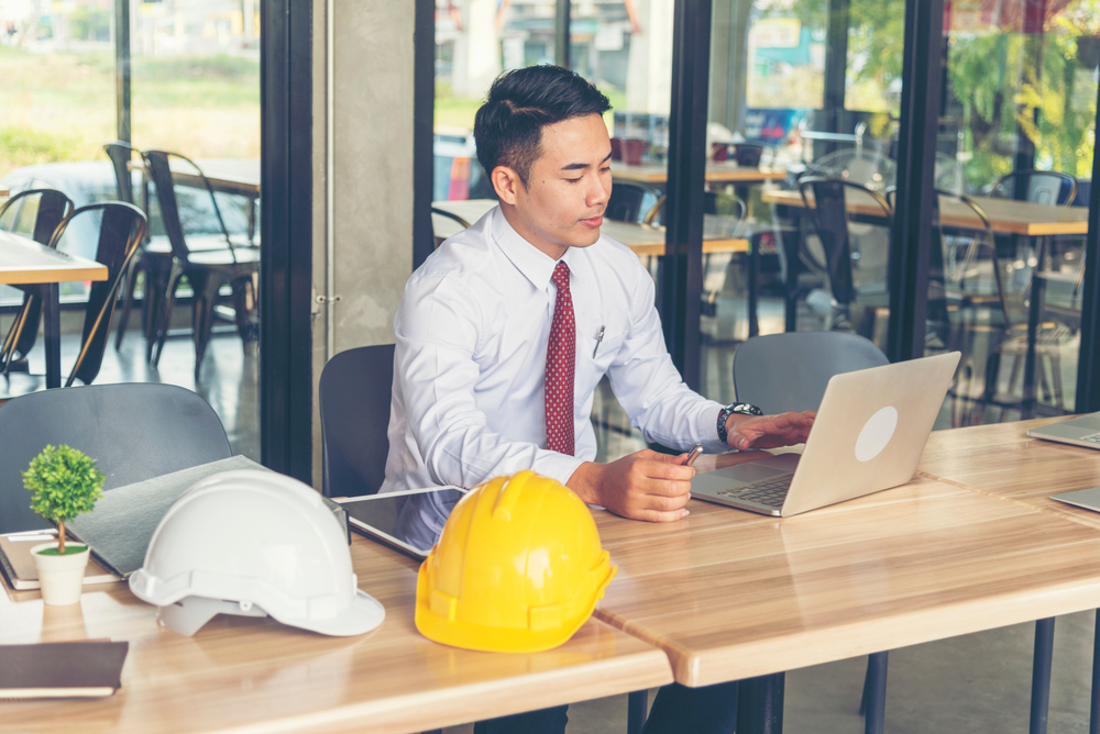 contractor with hard hat and laptop