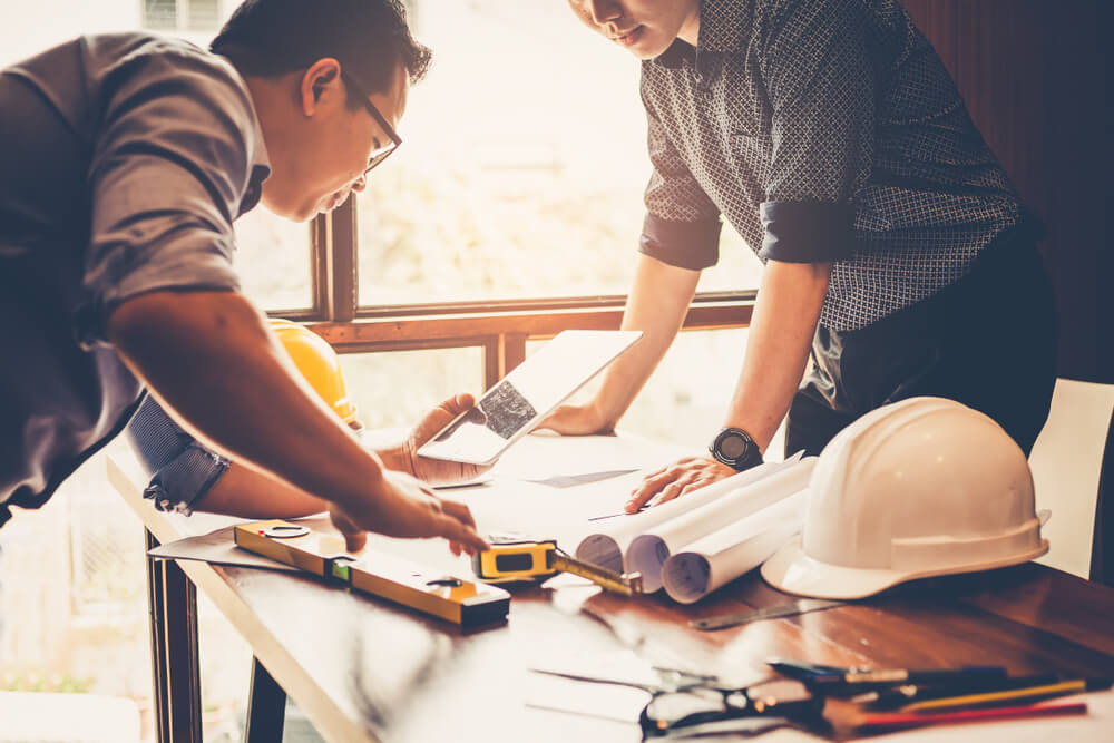 Engineers and businessmen are discussing construction projects in workplace.