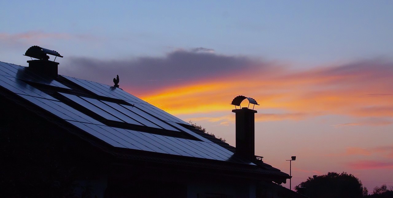 Solaranlage auf einem Dach mit Sonnenaufgang im Hintergrund