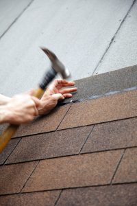 roofer hammering nails in roof