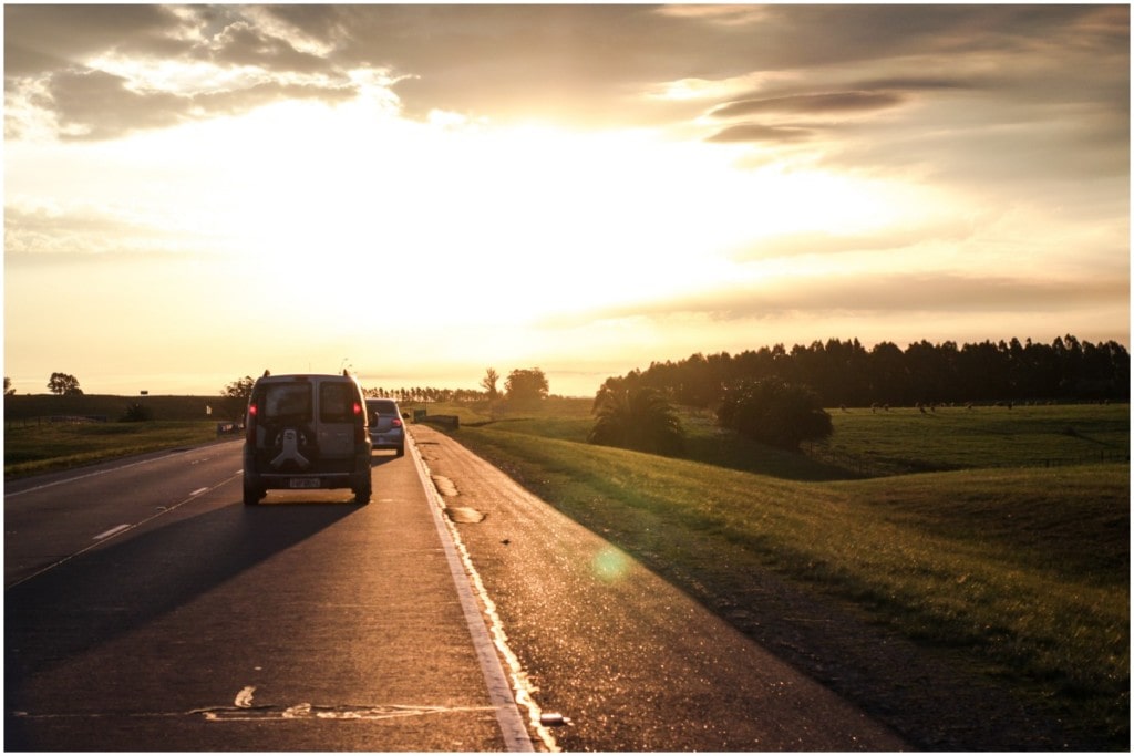 car driving in small town with rolling hills with