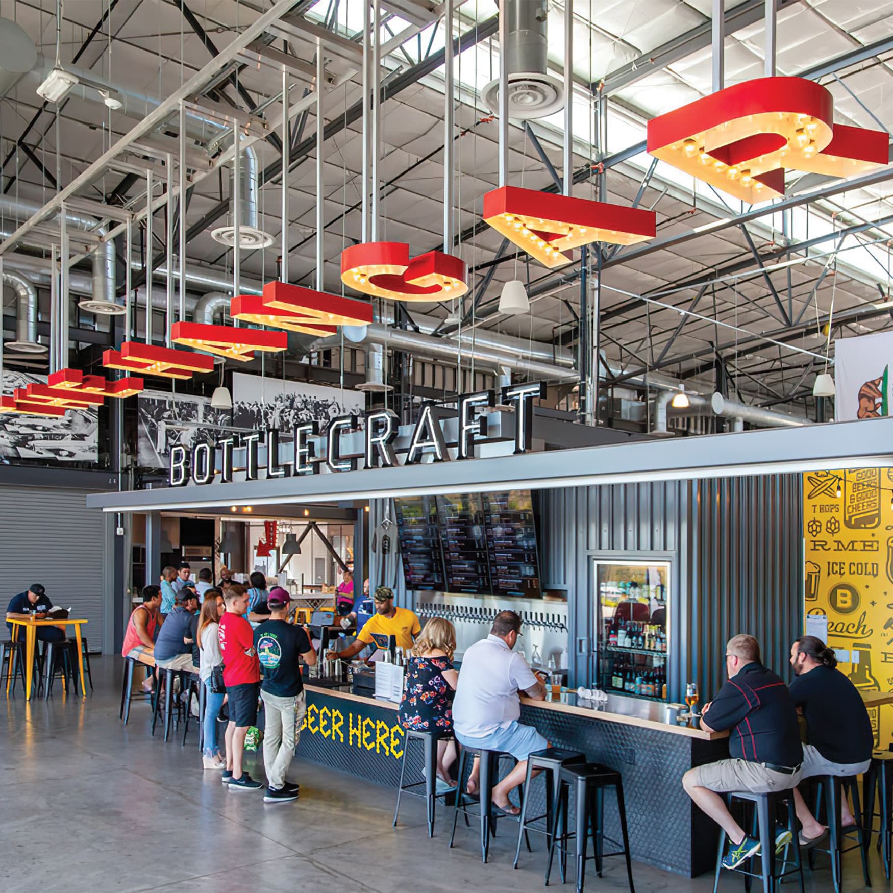 Suspended Hangar identity with colored returns and bulb lighting.