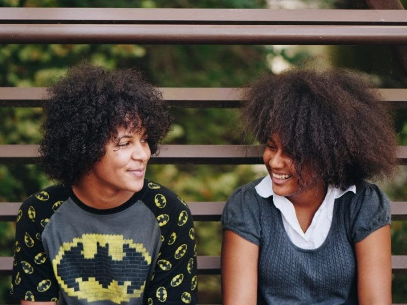 Two young people look at each other happily.