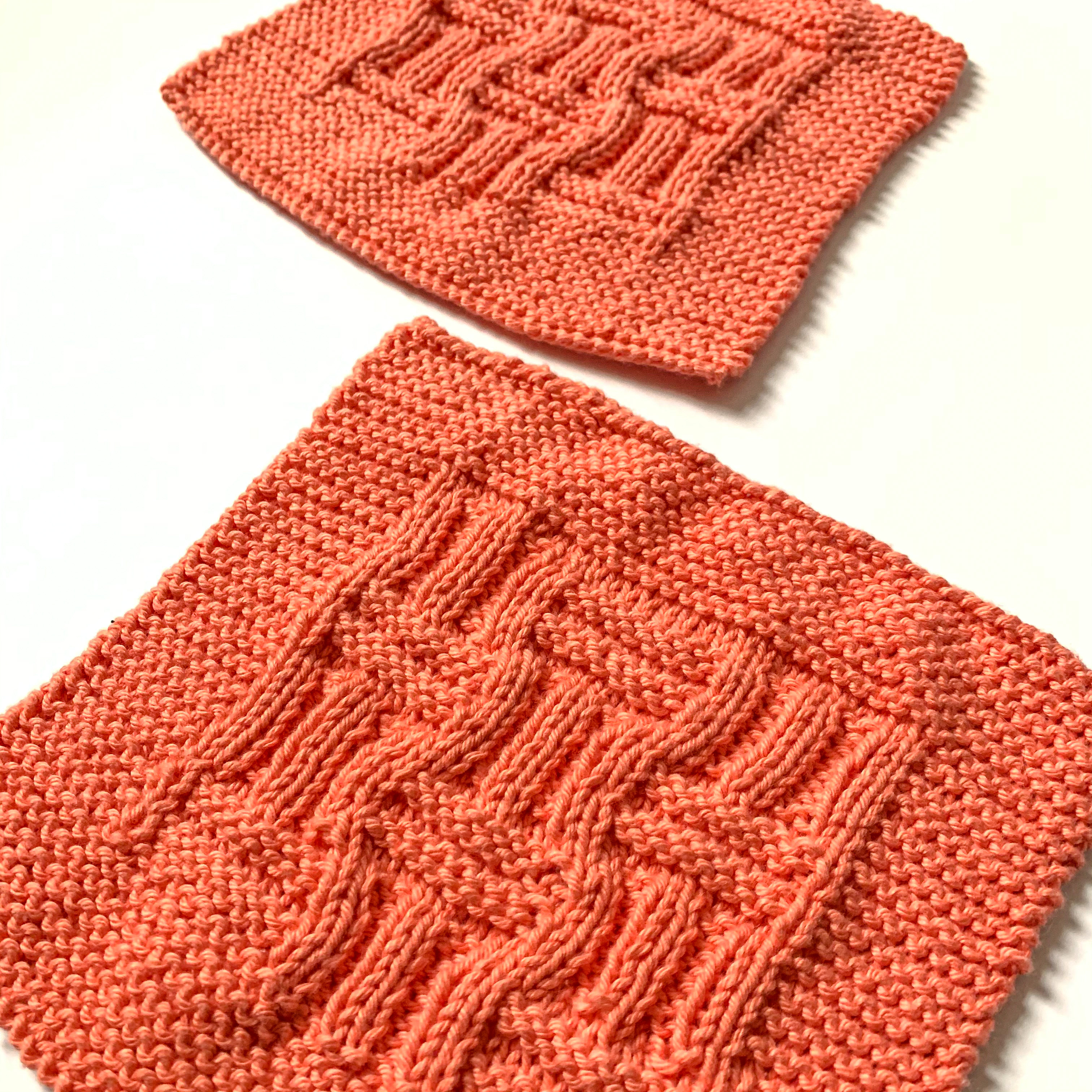 two square salmon knitted cotton dishcloths