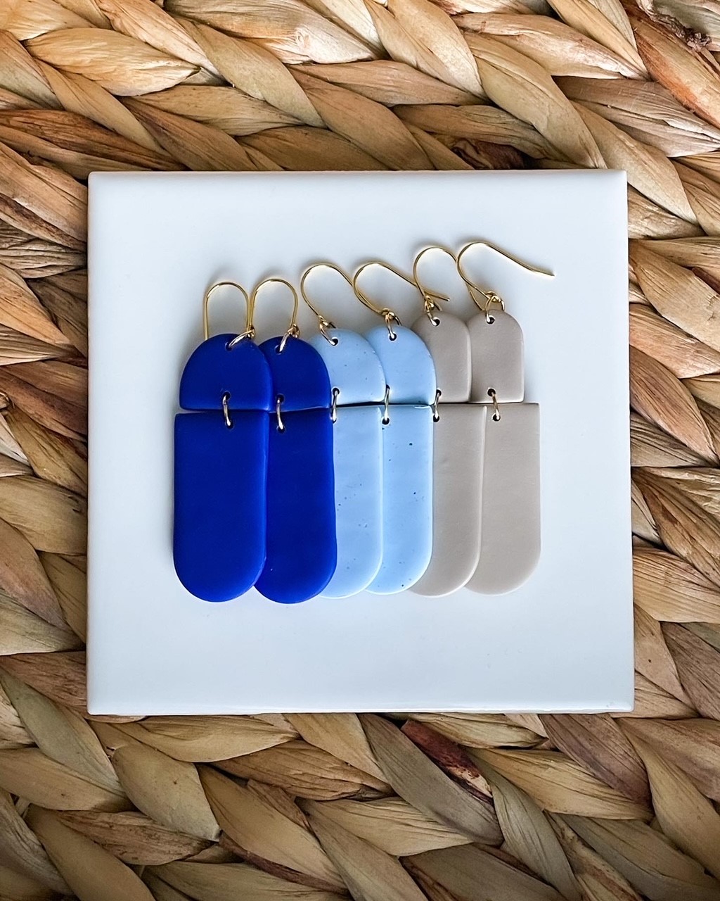 Polymer clay earring basics collection of three pairs in a 2.5 inch oval shape, 1/4 inch topper, 3/4 inch attached bottom, in the colors of royal blue, baby blue with specks of black, and beige.