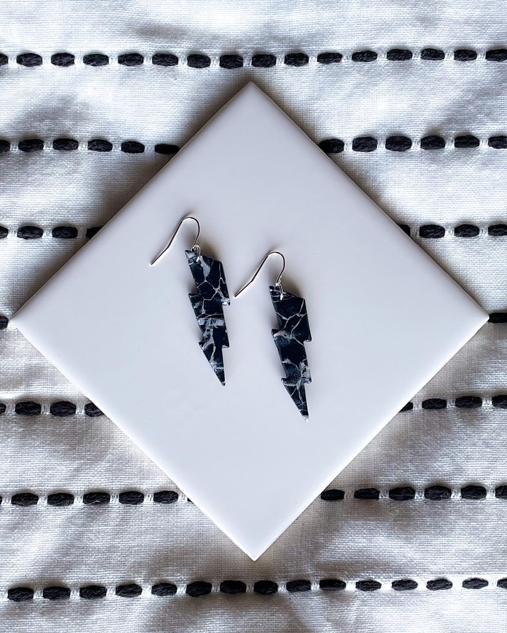 Faux marble stone lightning bolt earrings in black with white streaks.