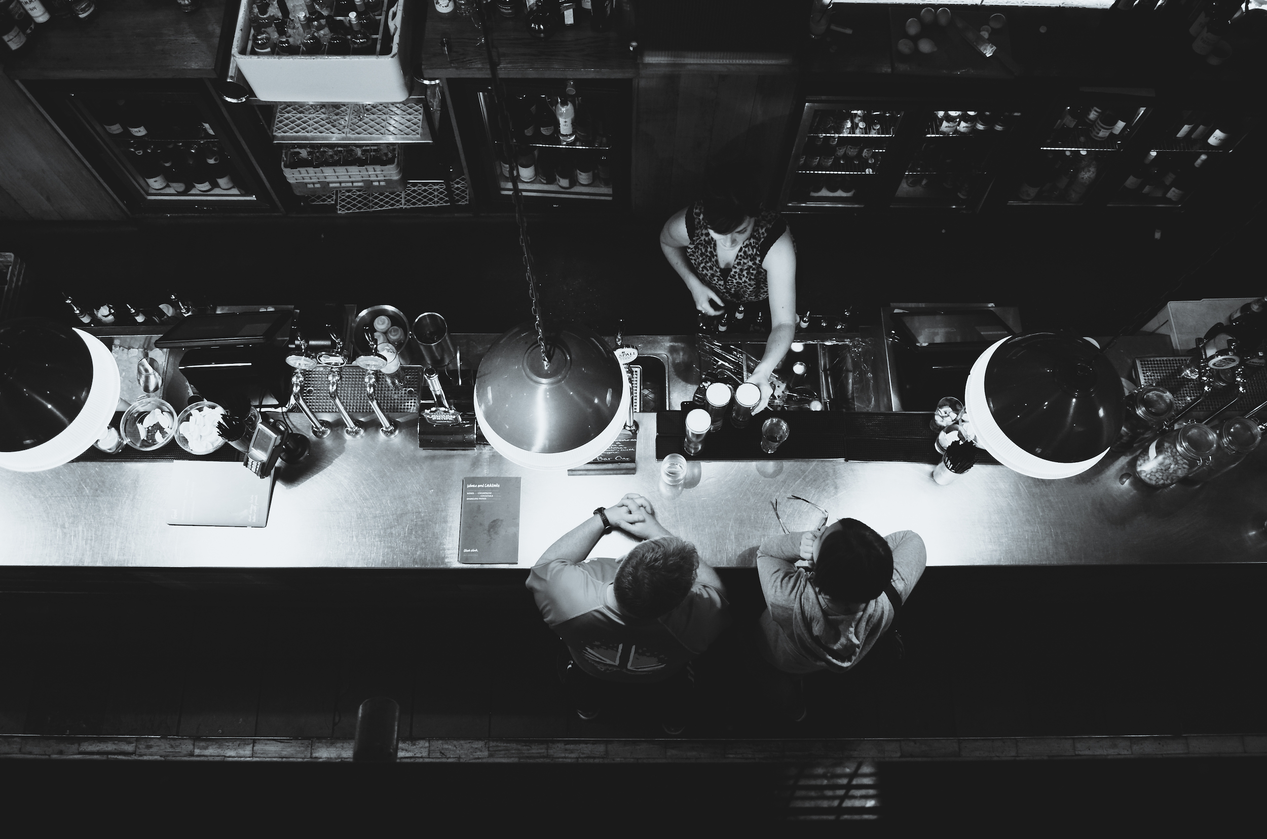 Overhead view of two people drinking in a bar