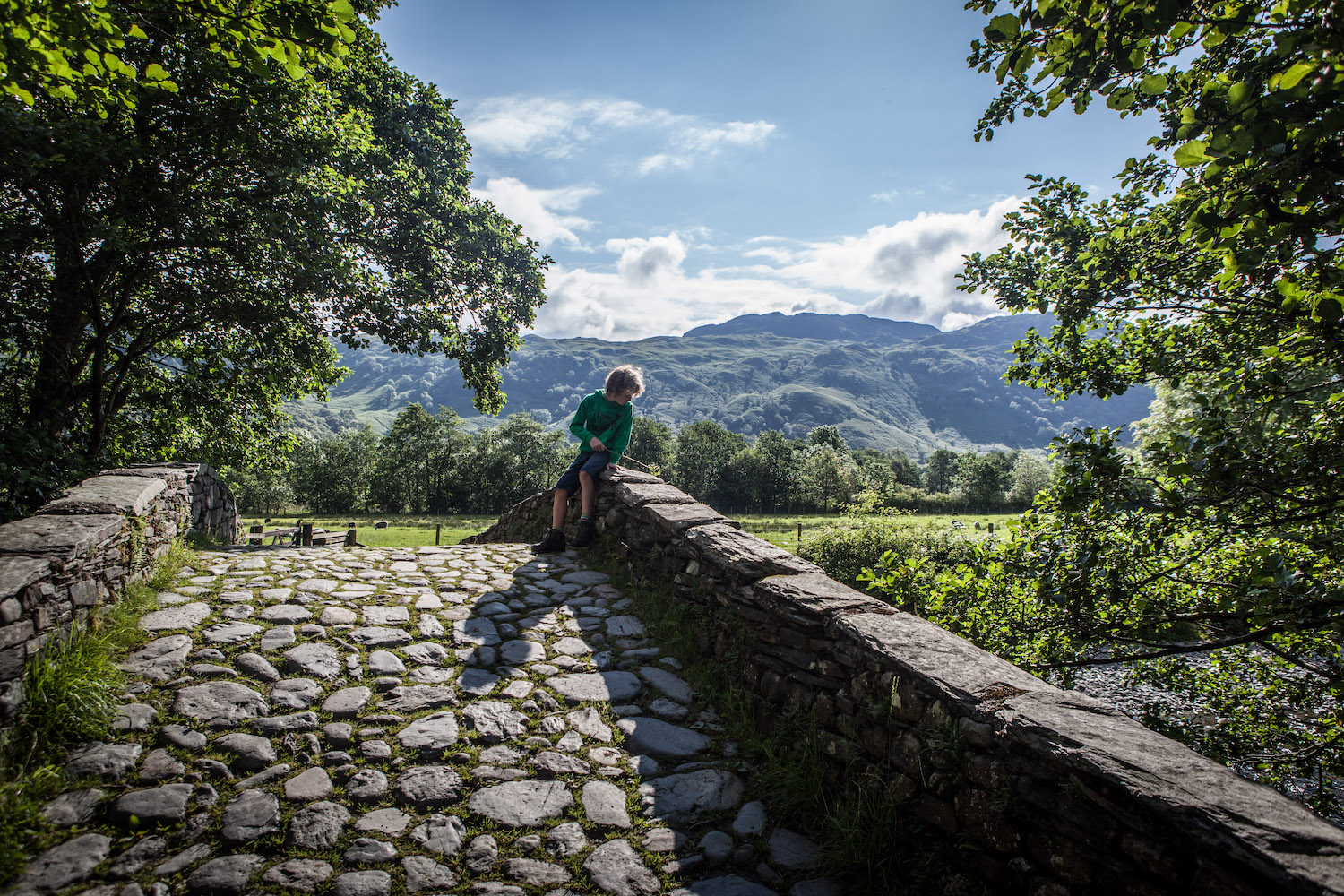 Boy looking over a bridge in the Lake District, England