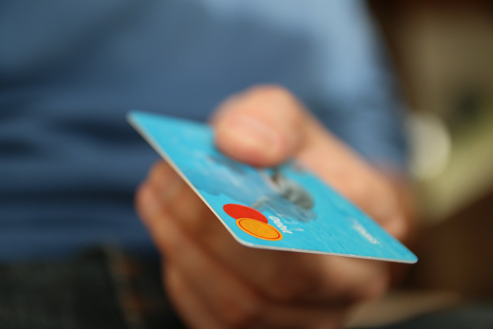 personne tendant une carte bleue