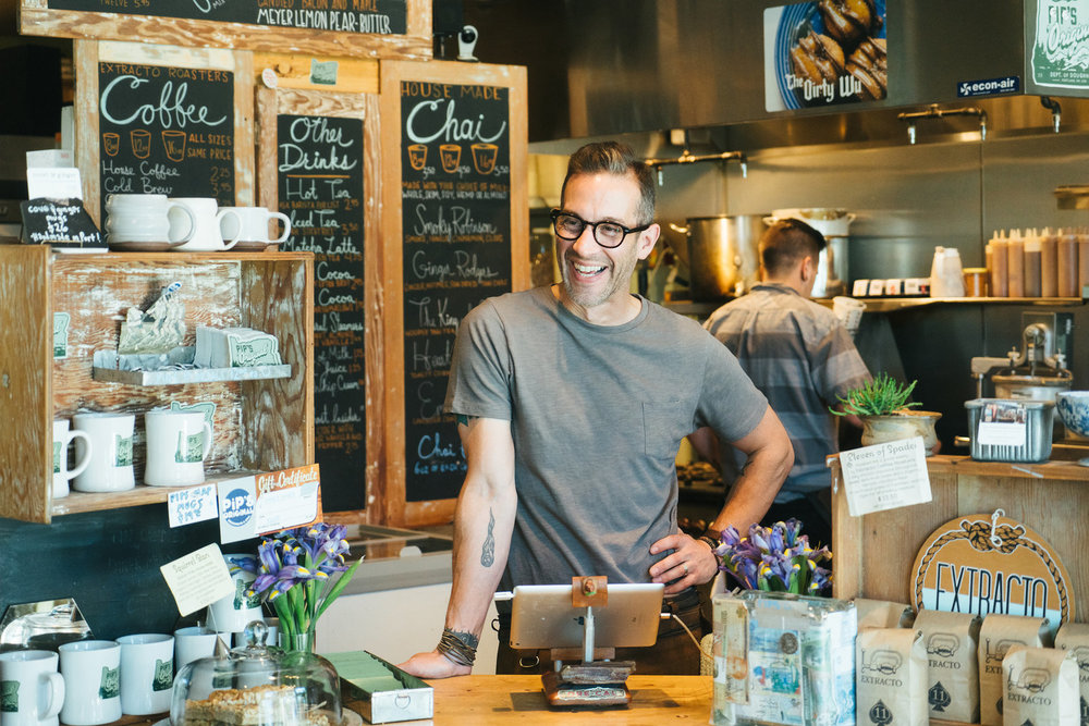 Nate Snell, the owner of Pip's Original Doughnuts in Portland, Oregon — stands at the register