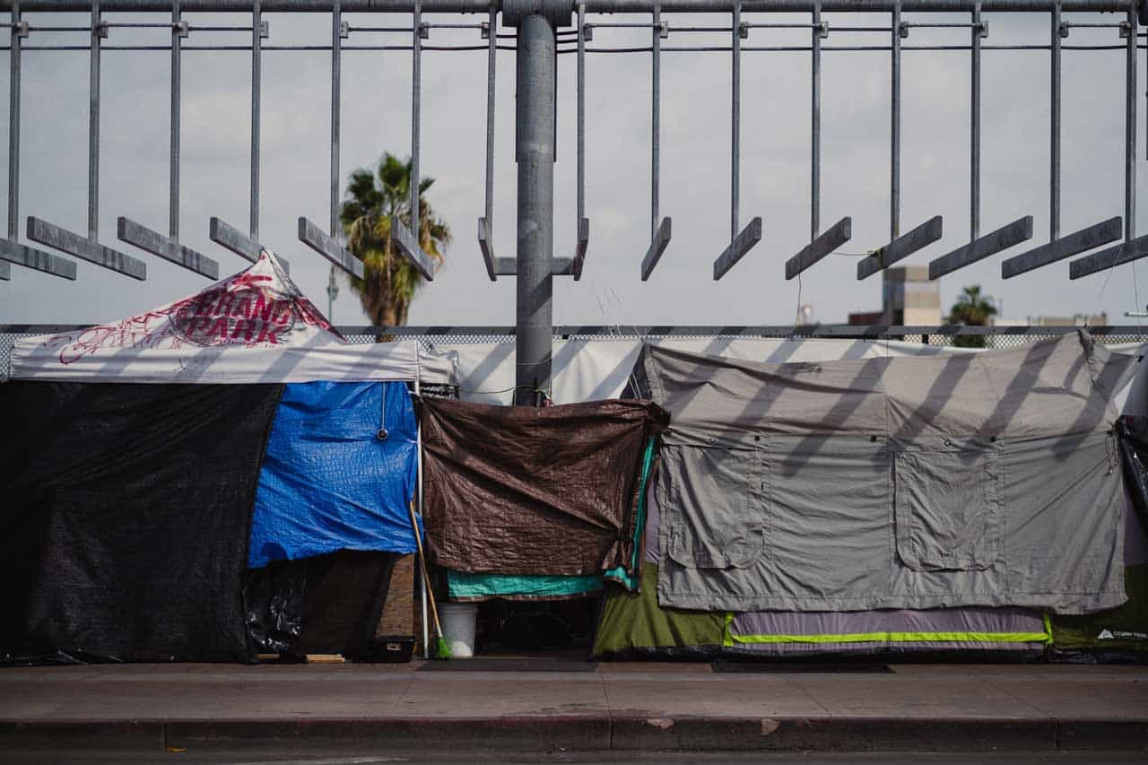 A series of ourdoor makeshift tent homes next to a sidewalk