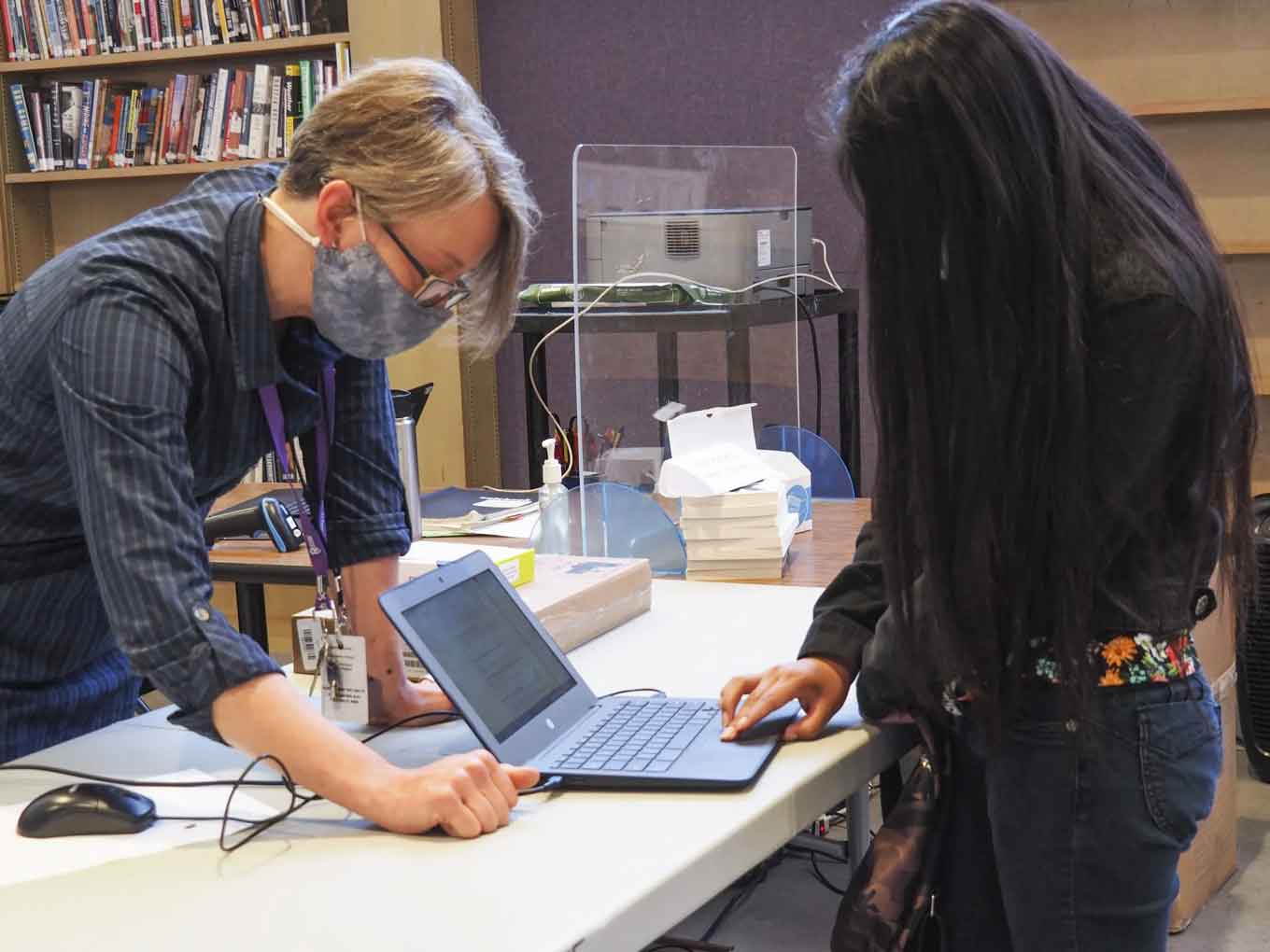 Jen Bender, the data tech lead at Castlemont High School, gives a new student her #OaklandUndivided Chromebook and hot spot in May 2021.