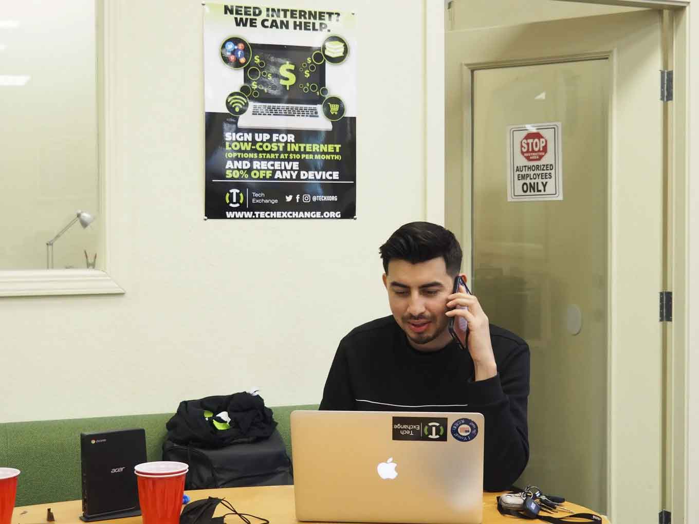 Samuel Aristondo, Tech Hub’s operations manager, is seen speaking in Spanish with a family