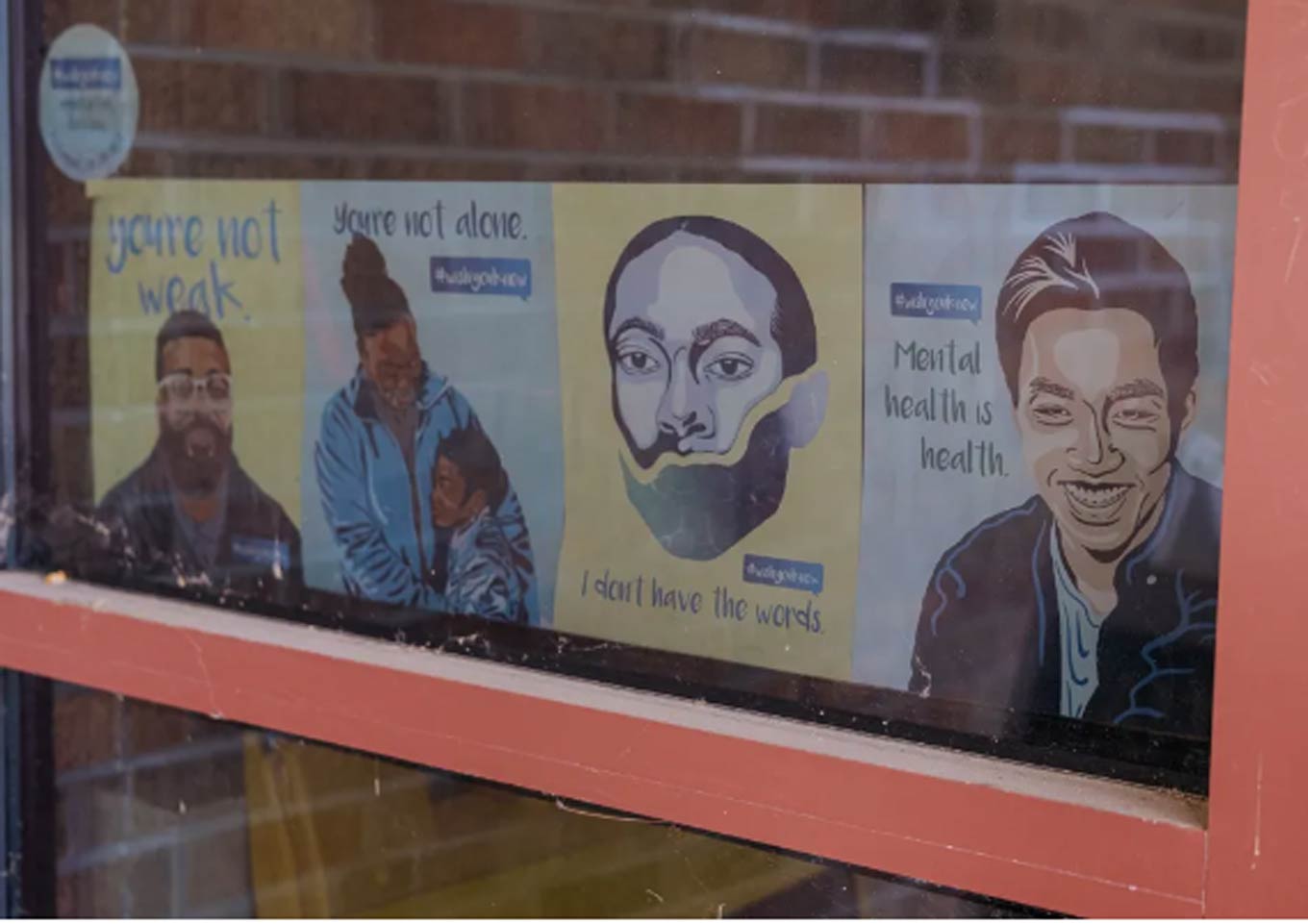 A window with posters with positive mental health messages