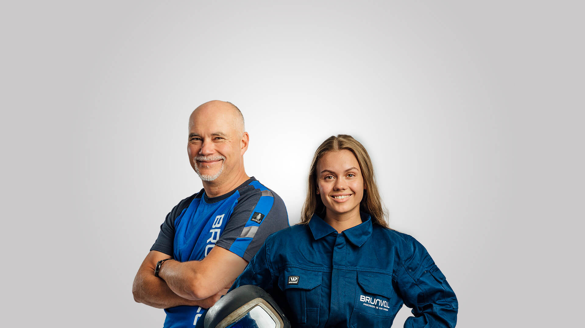 Two smiling Brunvoll employees on a grey background