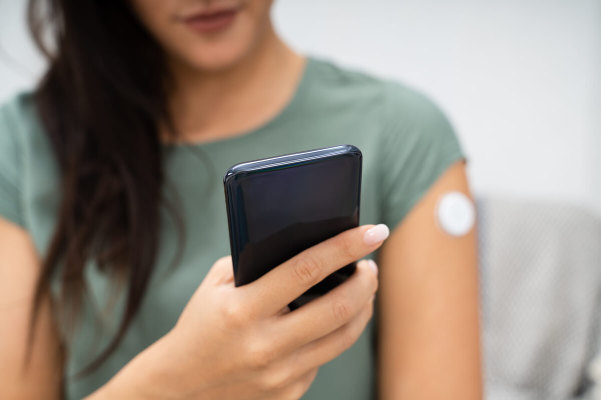 High blood sugar at night: A woman checks her CGM readings on her cellphone